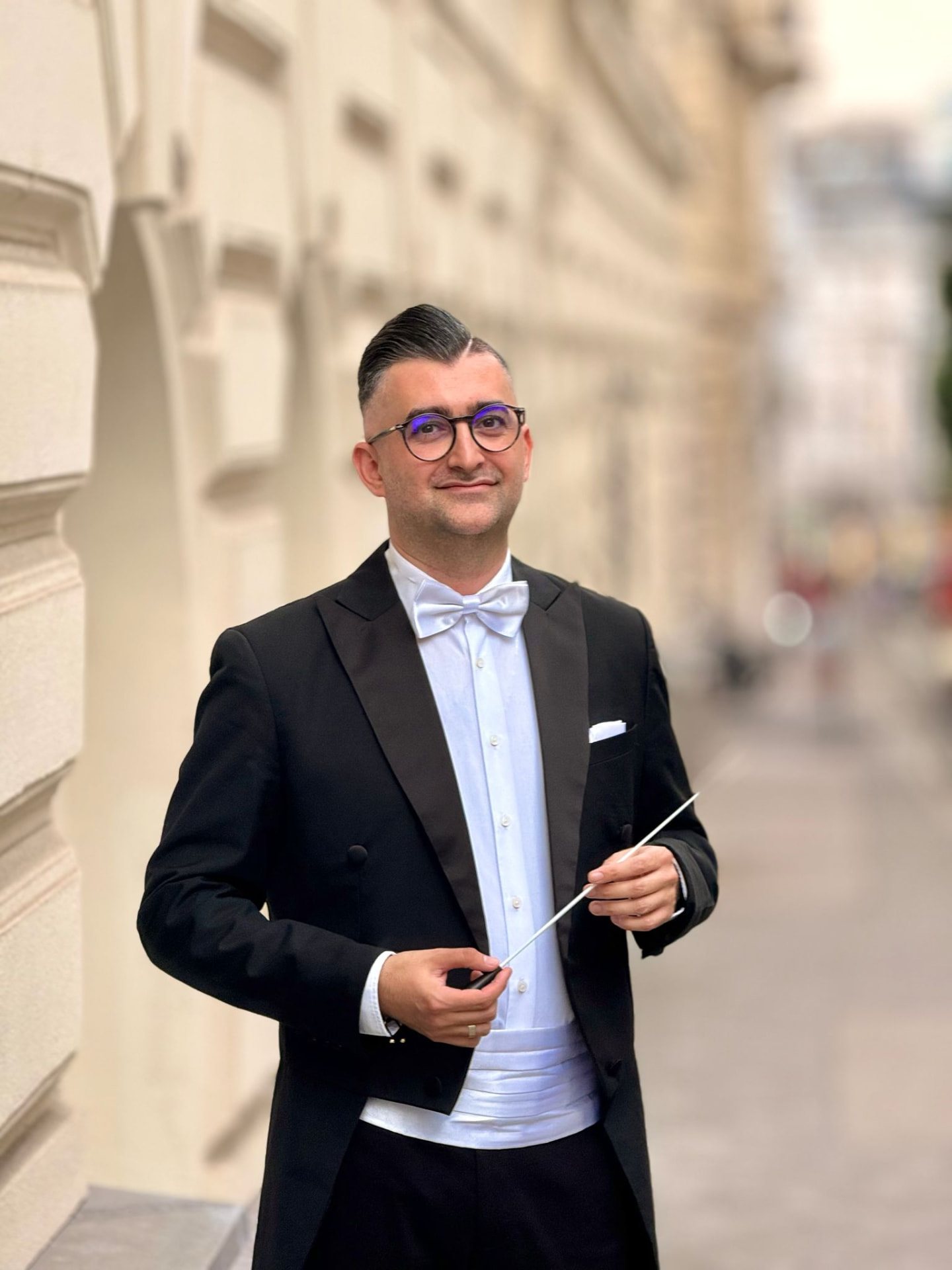 Portrait of Ion Scripcaru, artistic director of Metropolitan Kammerorchester Wien, holding a baton
